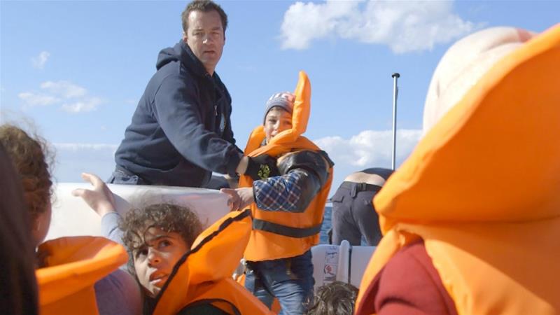 Photo of Greek Coast Guard captain on rescue boat with refugee children.